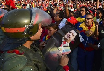 Un militar custodia el féretro de Chávez ante la marea que abarrotó las calles de Caracas. (Luis ACOSTA/AFP)