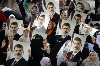 Seguidores de los Hermanos Musulmanes muestran fotografías de Morsi en una concentración. (Mohamed EL-SHAHEDAFP)