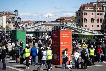 Turistas esperando a pasar el control del ticket para entrar en Venecia.