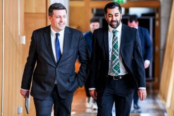 El primer ministro, Humza Yousaf, y el parlamentario Jamie Hepburn, en el Parlamento escocés.