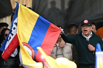 El presidente de Colombia, Gustavo Petro, con una bandera colombiana y otra del M-19 durante su discurso del 1 de Mayo. 